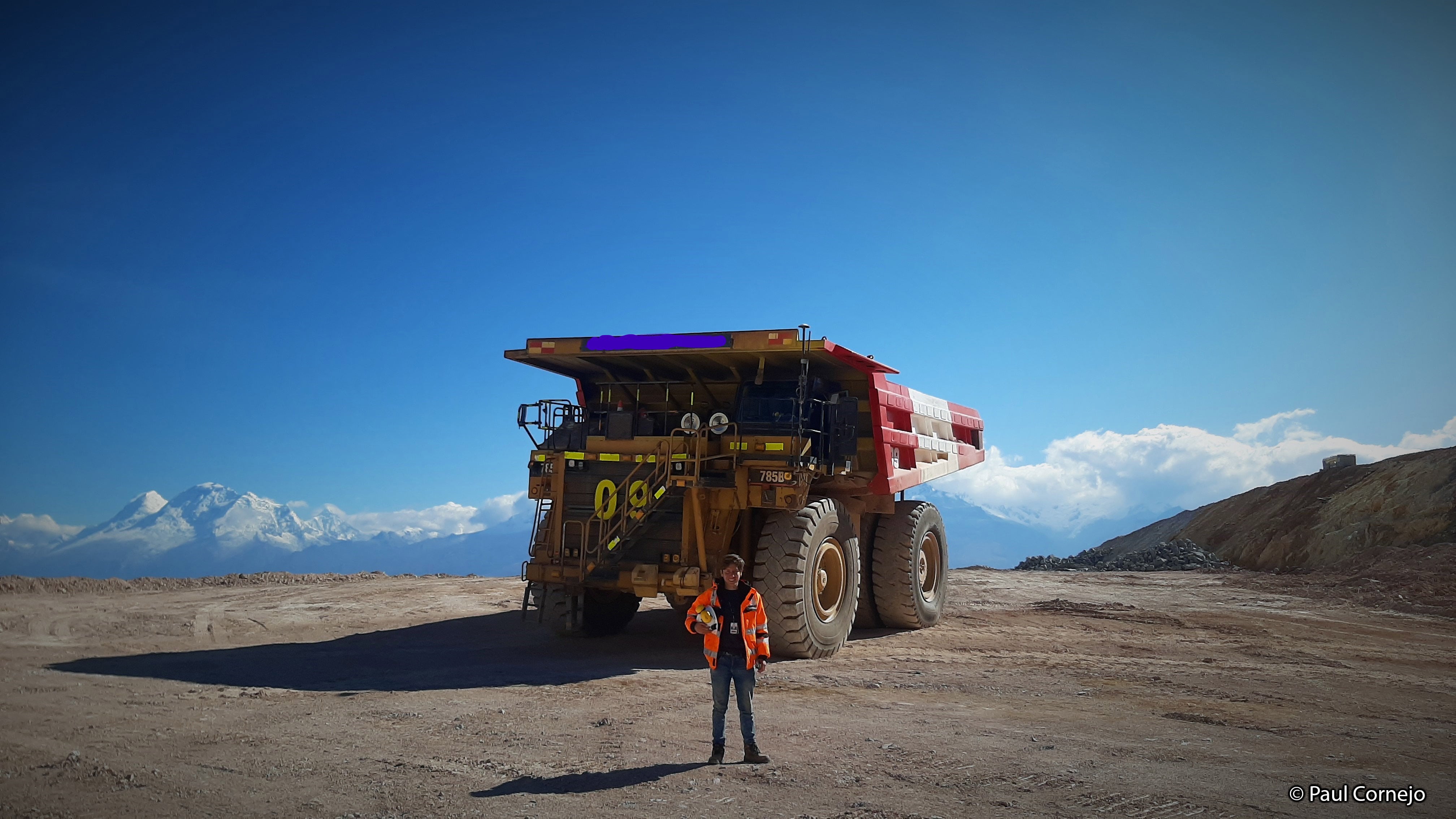 Honorable mention photo by Paul Cornejo: Mine worker in orange safety jacket in front of a mining dump truck